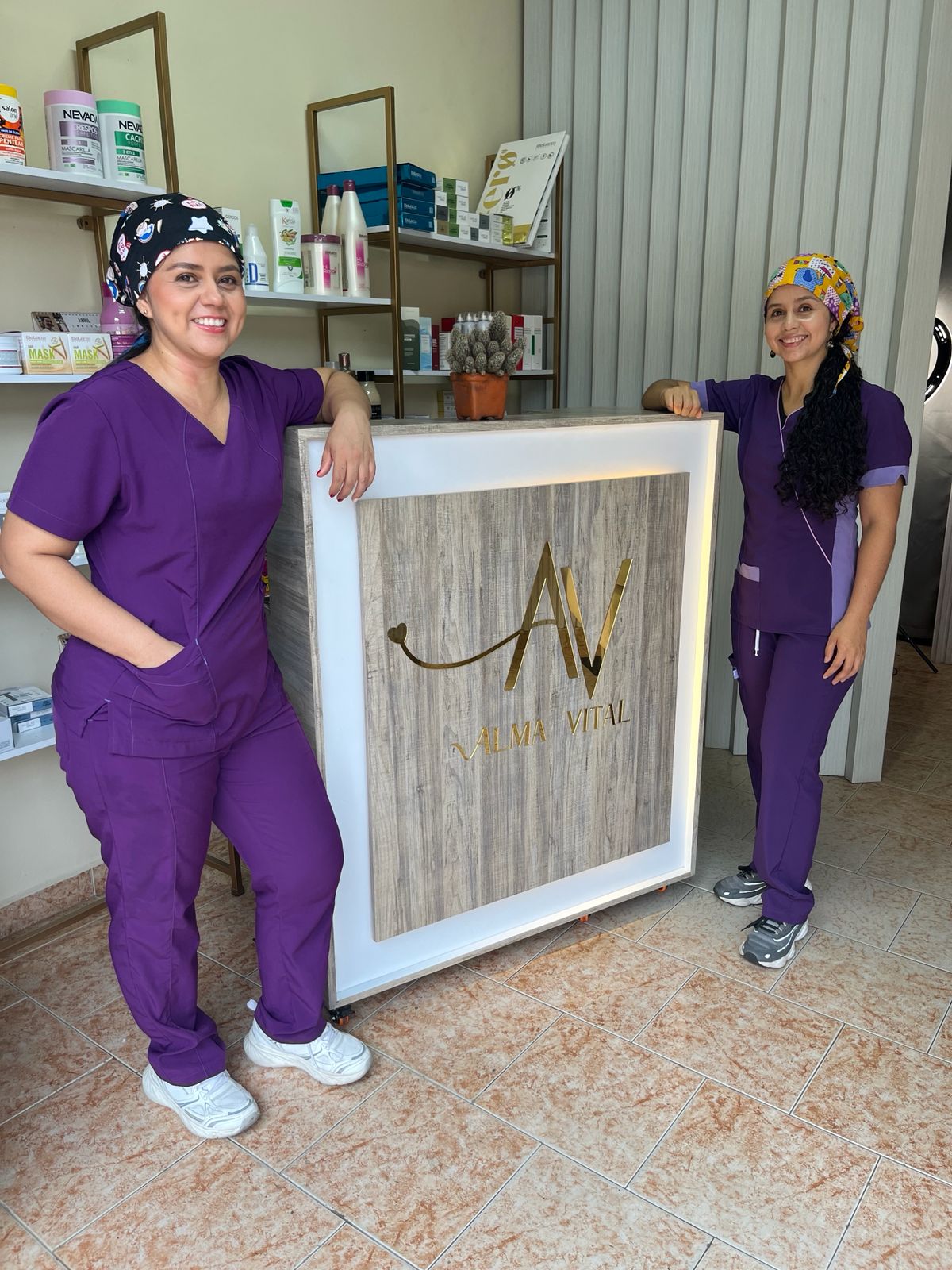 Jazmín y Jenny, hermanas socias de Alma Vital, junto al logo del salón